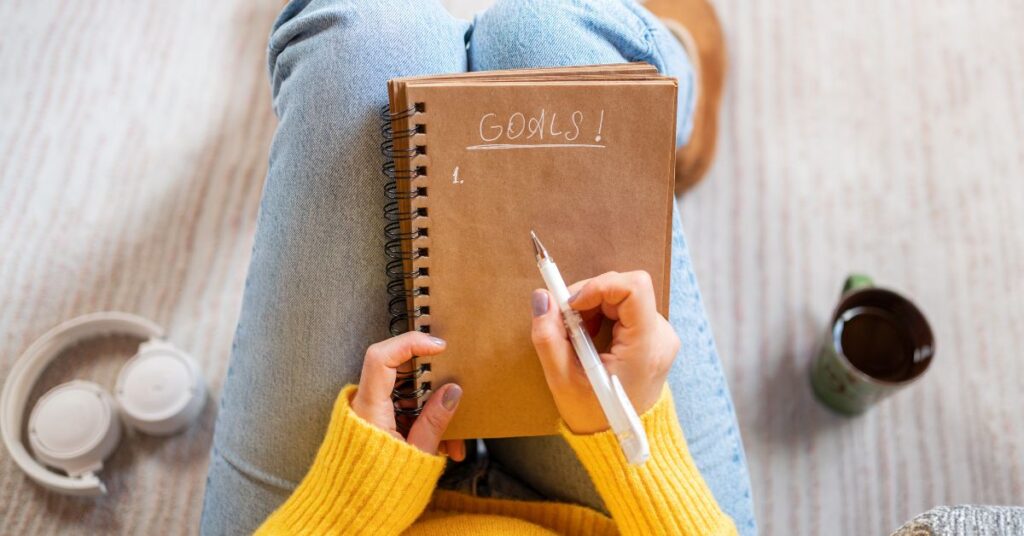 Woman writing her goals in a journal