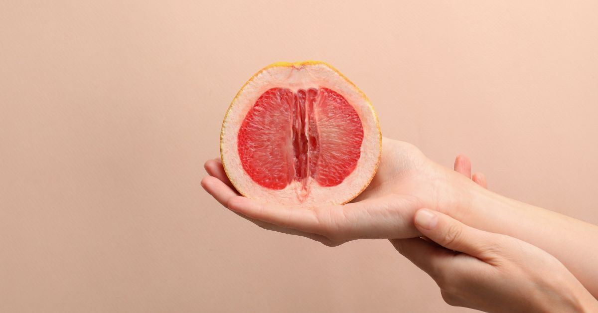 A woman holding a sliced grapefruit