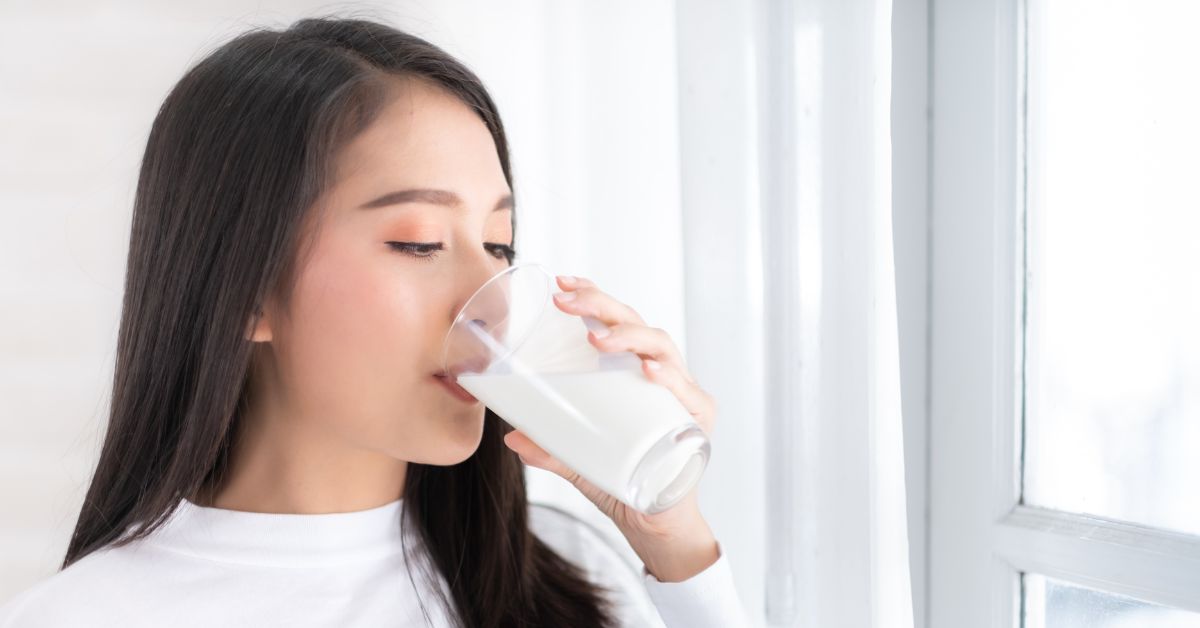 A woman drinking a glass of milk