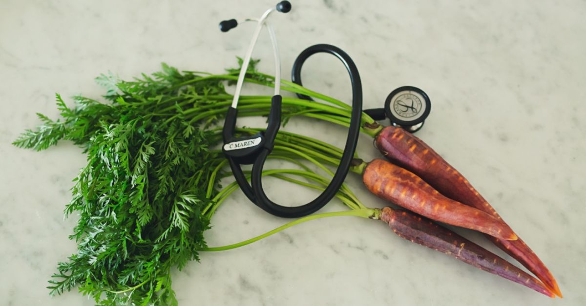 A flat lay of carrots and a stethoscope
