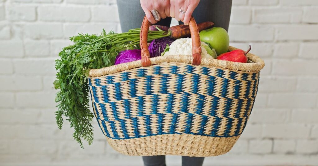 A woman holding a bag full of vegetables